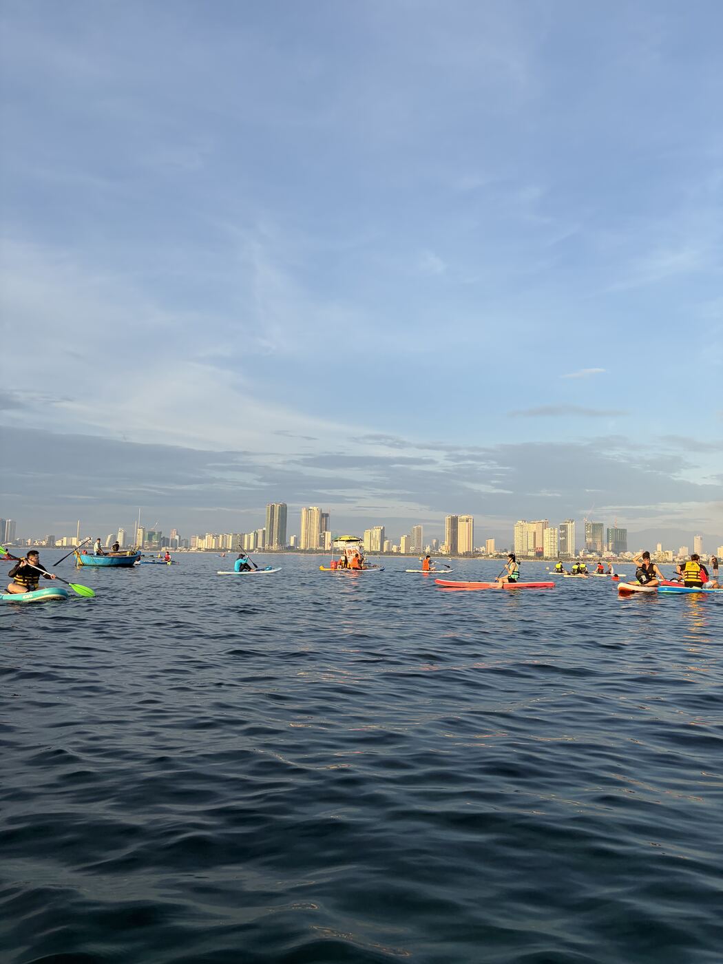 SUPで沖に出て見えるダナン市街のスカイライン、朝日を浴びるビル群